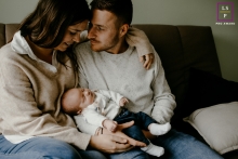 Celebrating Family Bliss: Stunning Arles Portrait Captures Love and Tranquility on the Cozy Couch A heartwarming lifestyle portrait captured in Arles, showcasing a family's coziness and love as they relax together on the couch with the new baby