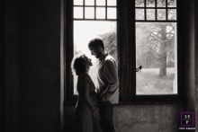 This captivating lifestyle portrait showcases a pregnant couple in Haute Savoie, France. Standing by a window, they lovingly showcase their growing family.