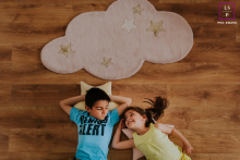 At Ile-de-France in France, under the stars, a lifestyle image was created showing a young brother and sister lying on their backs next to each other on wood floors during a portrait session.