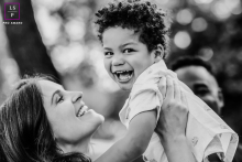A happy mom lifts her young son up in a black and white picture at a park in Oakland, California creating a joyful image filled with smiles and laughter.