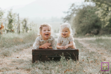 Irmãs se unindo em Colmar, guardando memórias através de sorrisos brincalhões durante uma sessão de fotos divertida.