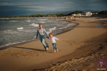 In Puglia, Italy, a mother and her 4-year-old son enjoy a peaceful day at the seaside in autumn, with the gentle waves lapping at their feet and the cool breeze rustling through their hair, as they share a moment of bonding by the shore.