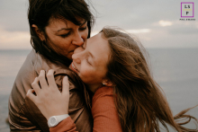Mother and daughter sharing nostalgia at their childhood beach in Montpellier, captured in a vibrant lifestyle portrait.