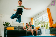 Leaping with Joy: Capturing Carefree Moments in Hérault An energetic young man, with a playful smile, jumps off a couch in Hérault, France, capturing the carefree spirit of his laid-back lifestyle.