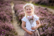 A pretty girl stands amidst a blooming flower field in Noord-Holland, The Netherlands. The vibrant scene captures her joy and the vivid colors of the blossoms, reflecting the beauty of nature and youthful wonder.