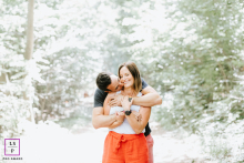 In Haute-Savoie, a lifestyle couple portrait captures a tender embrace as one partner plants kisses on the other's neck. The image beautifully showcases their affectionate bond amidst the serene, picturesque backdrop of the region.