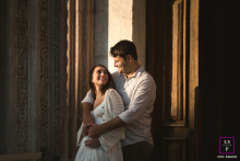 In Tuscany at the Siena Cathedral, sunlight illuminates a couple sharing eye contact. The portrait captures their deep connection and the awe-inspiring beauty of the historic setting.