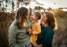 A family of three enjoys the sunset in Portland, Oregon. The daughter looks at her father with adoration, creating a sweet and loving portrait.