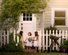 Three sisters are laughing in front of a garden entrance in Chattanooga, Tennessee. The portrait captures their candid and joyful interaction.