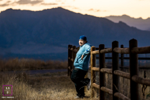 Sunset Reflection: Boulder Senior's Peaceful Portrait In Boulder, CO, a high school senior leans on a fence at sunset. Soft light from the photographer highlights their features, with warm sunset tones creating a peaceful and reflective scene.