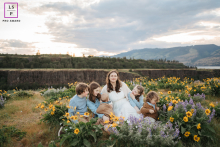 A loving mother in Mosier, Oregon, is surrounded by her five beautiful children, including the new addition to the family. She is smiling and embracing her children.