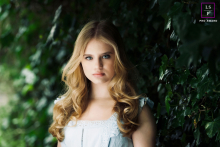 In Liverpool, UK, a young woman with stunning eyes looks directly at the camera, her gaze captivating in a simple portrait.