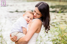 In Overijssel, Netherlands, a mother and child cuddle closely outdoors, their faces nestled together and framed by natural surroundings.