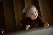 Portland Staircase Smile: Cheerful Girl Looks Up, Brightening the High-Angle Scene In Portland, Oregon, a girl smiles up at the camera from a staircase in a high-angle shot, her cheerful expression brightening the scene.