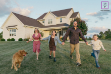Wisconsin Family Holding Hands Running Down Gentle Hill With Their Dog In Richfield, Wisconsin, a family holds hands and runs down a gentle hill together, their dog eagerly joining in the fun.