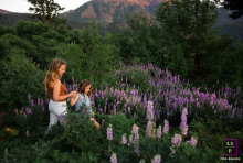 Portland Mother And Daughter Descend Hill Hand-In-Hand Through Wildflowers In Portland, Oregon, mom and daughter walk hand-in-hand through wildflowers, descending a gentle hill together.