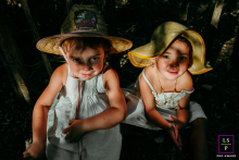 In La Grande Motte, France, two sisters enjoy time together on the beach, their faces lit by dappled sunlight.