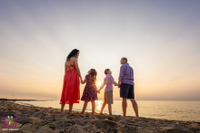 At Paine’s Creek Beach in Brewster, Massachusetts, four silhouetted figures stand together as the sun sets, radiating unity, rhythm, and presence in the gentle evening light.