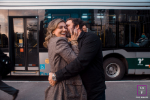 On Avenida Paulista in São Paulo, Brazil, a couple share passionate hugs and kisses amid city life, a bus and a leg visible, capturing vibrant urban energy.