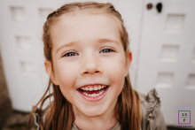 At Parc de Lacroix-Laval in Marcy l'Étoile, Rhône, a young girl looks squarely at the camera, offering a sweet smile.