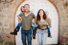 At Parc de Lacroix-Laval in Marcy l'Étoile, Rhône, parents give piggyback rides to their children, all four smiling at the camera.