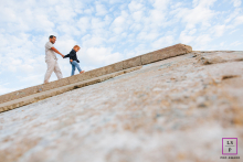 Father and young son walking hand-in-hand together in Tarnos, Landes, France, in a natural setting.