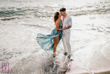 Lanzarote, Canary Islands: Romantic couple on a beach, her dress flowing gently in the wind.