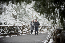 Romantic couple bundled up, walking hand-in-hand through a picturesque, snow-covered Central Park, NYC.