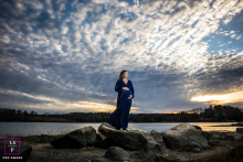 Beside the lake in Durham, this expecting mother stands against a sky filled with dramatic cloud patterns and fading light. The wide composition and flowing blue dress give the photograph strength, scale, and quiet anticipation.