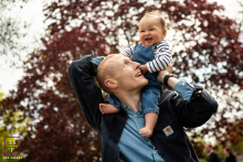 In St Albans, a father carries his laughing son on his shoulders beneath rich autumn leaves, both completely absorbed in each other’s joy. The upward angle and soft background blur give the photograph warmth, movement, and playful intimacy.
