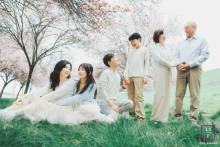 In San Ramon, California, three generations gather beneath blooming trees, each pair sharing its own quiet interaction. The soft spring light and layered composition give the portrait warmth, tenderness, and a gentle sense of family continuity.