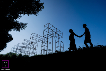 Expectant Couple Holds Hands Beside Geometric Art In Balijbos Zoetermeer An expectant couple holds hands in silhouette beside a geometric art structure in Balijbos, Zoetermeer, the Netherlands.