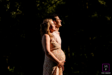 Expectant Couple Embraces In Warm Sunlight At Balijbos Zoetermeer Netherlands An expectant couple embraces in a beam of warm sunlight, lovingly cradling her pregnant belly in Balijbos, Zoetermeer, the Netherlands.