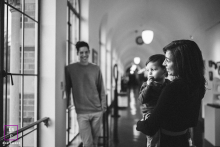 A family shares a candid portrait together beneath an arched hallway while sheltering from a rainy day in Seattle, Washington.